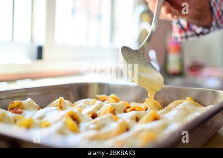 Zubereitung von hausgemachten Lumaconi gefüllt mit Tomatensauce und Hackfleisch. Hinzufügen von Käse und Béchamel-Sauce. Italienisches Pasta-Rezept. Stockfoto