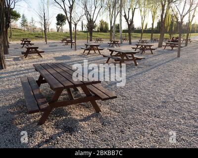 Reihen leerer Holzpicknicktische in einem Park Stockfoto