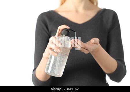 Nahaufnahme der Hände der Frau, die Desinfektionsmittel Gel aus Flasche Dipenser auf weißem Hintergrund isoliert Stockfoto