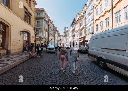 Blick auf die Kirche zwischen zwei Häusern in Prag gegen den blauen Himmel Stockfoto