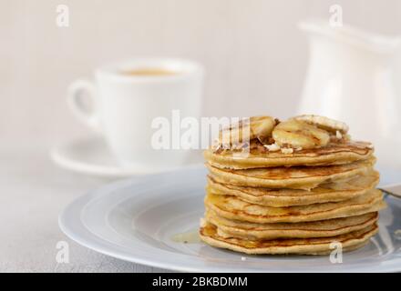 Leckere Bananenpfannkuchen. Kaffee mit Milch auf Hintergrund. Nahaufnahme. Stockfoto