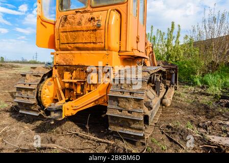 Industriebau Baustelle Bulldozer Nivellierung und Bewegung Boden während der Autobahn Gebäude. Gelbe Bulldozer auf einer lehmigen Baustelle Stockfoto