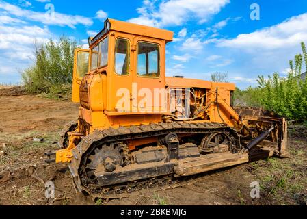 Industriebau Baustelle Bulldozer Nivellierung und Bewegung Boden während der Autobahn Gebäude. Gelbe Bulldozer auf einer lehmigen Baustelle Stockfoto