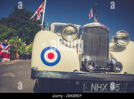 Niedriger Winkel, Nahaufnahme eines Oldtimers von Alvis, 1940s WW2 Kriegszeit-Sommerevent in Großbritannien. Kühlergrill und Scheinwerfer für Oldtimer-Alvis-Motorwagen. Stockfoto