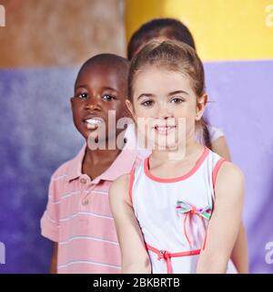 Verschiedene Kinder im Kindergarten stehen in einer Reihe Stockfoto