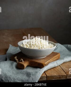 Schüssel mit Quark auf alten hölzernen Küchentisch Stockfoto