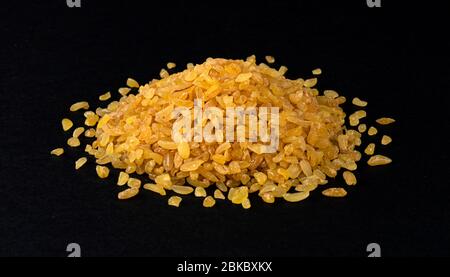 Haufen von trockenem Bulgur Weizen isoliert auf schwarzem Hintergrund Stockfoto