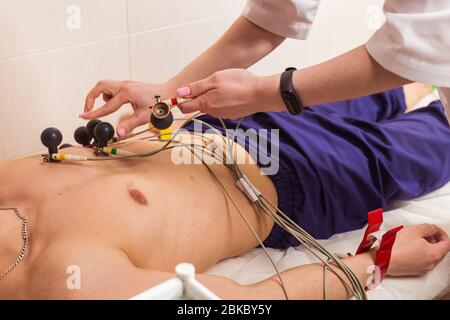 Medizin, Gesundheit und Herz Check-up-Konzept - männliche Patienten mit EKG-Elektrokardiogramm im Krankenhaus Stockfoto