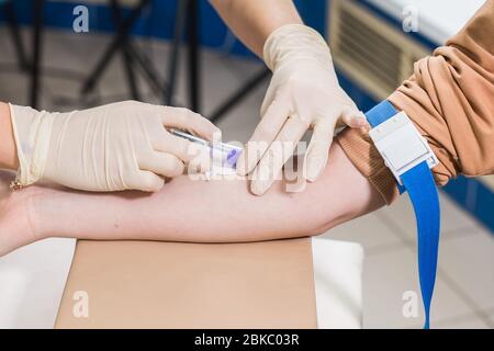 Covid-19, Pandemie und Viren Konzept - Nahaufnahme des Arztes nimmt Blut auf die Analyse. Stockfoto