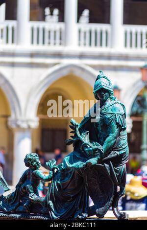 Eine Bronzeskulptur auf Jacopo Sansovinos Loggetta-Tor des Markuspforts mit dem Dogenpalast im Hintergrund. Venedig, Italien Stockfoto