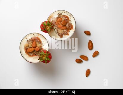 Frische Erdbeeren mit Sojoghurt, Haferflocken, Mandeln, roter Fruchtmarmelade, Kokosmehl und Chiasamen. Stockfoto