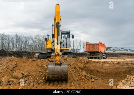 Ein großer Baubagger von gelber Farbe auf der Baustelle in einem Steinbruch für den Abbau. Industriebild Stockfoto