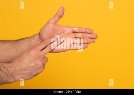 Zugeschnittene Ansicht des Mannes, der Geste in tauber und stummer Sprache mit Händen auf gelb isoliert zeigt Stockfoto