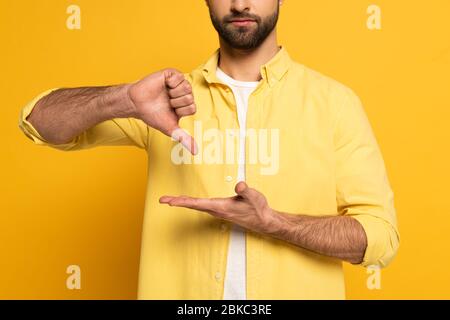 Zugeschnittene Ansicht des bärtigen Mannes, der Geste in tauber und stummmer Sprache auf gelbem Hintergrund zeigt Stockfoto