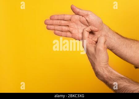 Zugeschnittene Ansicht des Mannes, der Geste in tauber und stummer Sprache auf Gelb isoliert zeigt Stockfoto