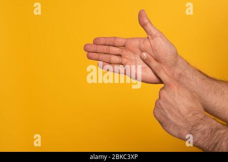 Zugeschnittene Ansicht der männlichen Hände, die Geste in tauber und stummer Sprache auf gelb isoliert zeigen Stockfoto
