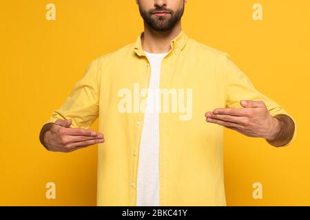 Beschnittene Ansicht des Mannes mit taub und stumm Sprache auf gelbem Hintergrund Stockfoto