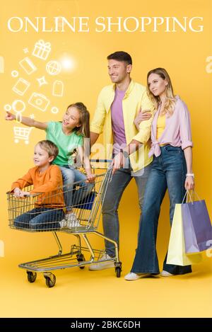 Eltern mit Einkaufstaschen und Kinder gestikulieren und sitzen im Warenkorb auf gelb, Online-Shopping-Illustration Stockfoto