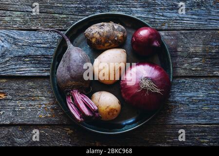 Verschiedene Bauerngemüse auf einem Teller: Rüben, Kartoffeln und Zwiebeln gesundes Bio-Superfood Stockfoto