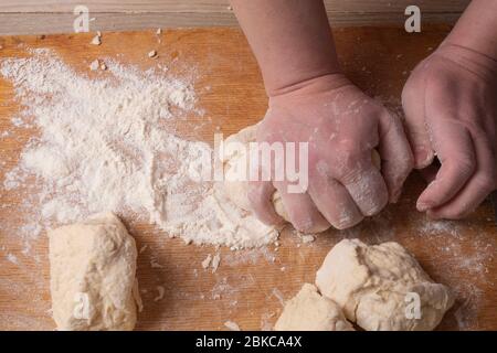 Weibliche Hände mischen Teig in der Küche. Stockfoto