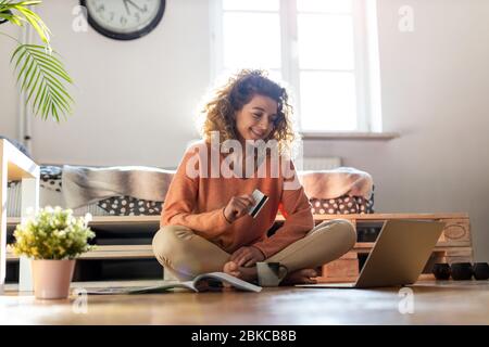 Lächelnde Frau zu Hause online-shopping Stockfoto