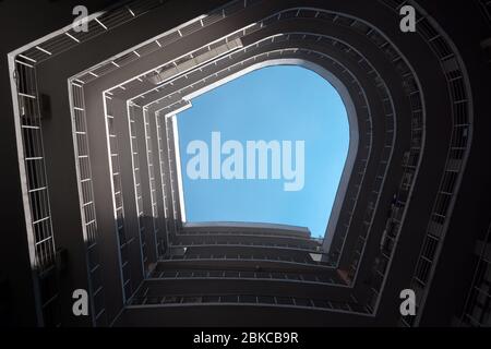 Eine untere Perspektive des abgerundeten Gebäudes. Immobilien. Moderne Gebäudekonstruktion. Außenansicht. Architekturszene. Spiralstruktur Stockfoto