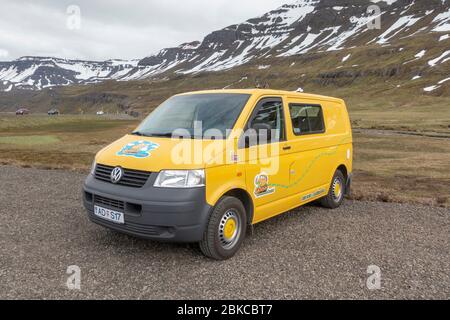 Ein Schnecke.ist ein leuchtend gelber Mietwagen, ein umgebauter Volkswagen T5 Transporter (Deutsche Telecom) an einem typischen Straßenabschnitt in NE Island. Stockfoto