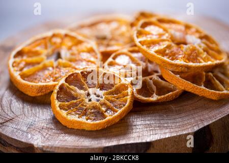 Trockene Zitrusfrüchte auf Holz geschnitten. Getrocknete Orange, Zitrone, Mandarine. Gesunde und natürliche Snacks Stockfoto