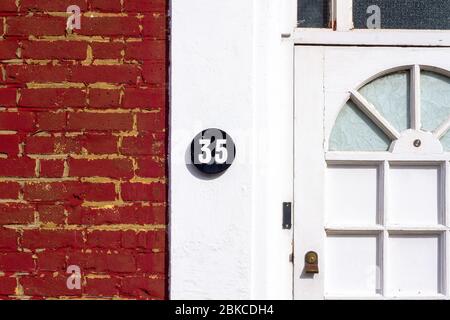 Hausnummer 35 auf einer weißen Hauswand Stockfoto