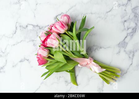 Bouquet von schönen Pfingstrosen Tulpen auf Marmor Hintergrund. Draufsicht. Muttertag, Hochzeitstag Blumen Konzept Stockfoto