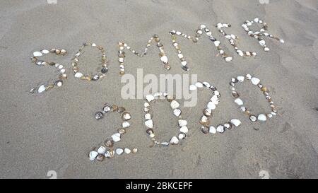 Sommer 2020, Deutsch Wort mit Muscheln am Strand geschrieben. (Sommer 2020) Stockfoto