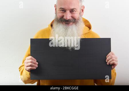 Porträt von reifen grauhaarigen bärtigen Mann mit schwarzem Blatt über isolierten weißen Hintergrund, selektive Fokussierung Stockfoto