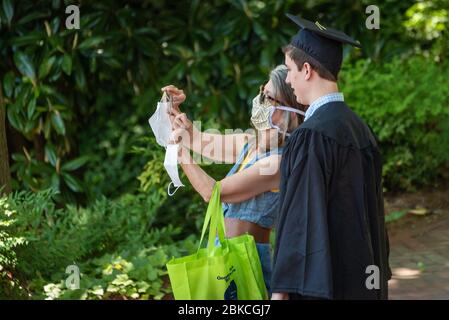 Mutter mit Gesichtsmaske und Sohn eines College-Absolventen erhalten ein Selfie zusammen bei Georgia Tech in Atlanta, Georgia während der Coronavirus-Pandemie. (USA) Stockfoto