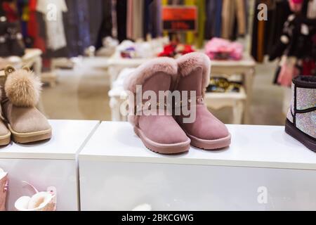 Rosa UGG im Schaufenster, Damen Winter warme Schuhe. Winterkleidung, Mode und kalte Jahreszeit Konzept. Stockfoto