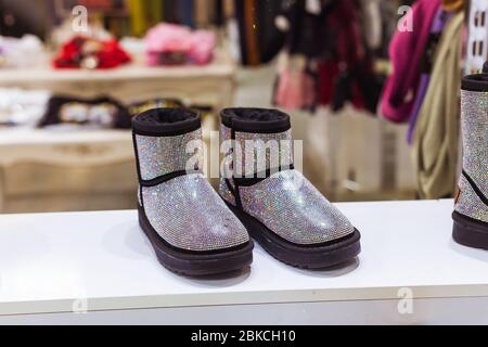 Silber UGG im Schaufenster, Damen Winter warme Schuhe. Winterkleidung, Mode und kalte Jahreszeit Konzept. Stockfoto