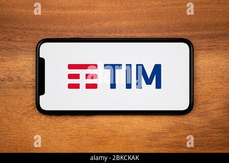 Ein Smartphone mit dem Logo von Telecom Italia (Tim) liegt auf einem einfachen Holztisch (nur für redaktionelle Zwecke). Stockfoto