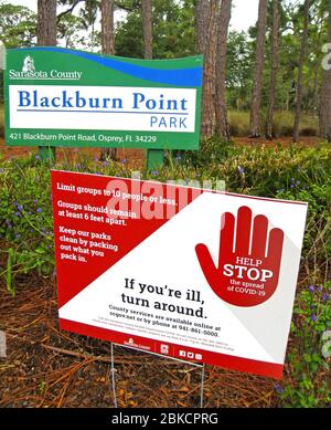 Dieses Schild warnt anfalle kranken Besucher, nicht in einen County Park in Florida, USA, zu gelangen. Ziel ist es, die Ausbreitung von COVID-19, der neuartigen Infektionskrankheit des Coronavirus, die seit 2020 eine weltweite Pandemie auslöste, zu stoppen. Das Schild erinnert auch an lokale Regierungsrichtlinien, die Gruppen auf maximal 10 Personen begrenzen und die Gruppen mindestens 1.8 Meter voneinander entfernt bleiben sollten. Stockfoto