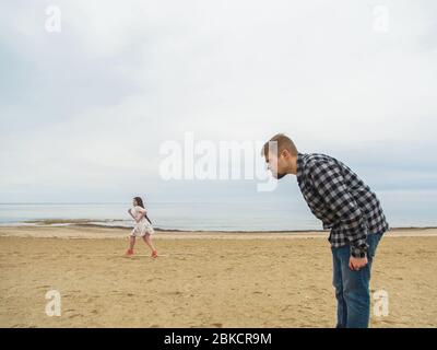 Unzufriedener Mann schimpft seine Frau am Strand. Konflikte, Streit und Beziehungsprobleme. Stockfoto
