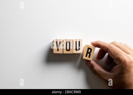 ' Ihr ' Text aus Holzwürfel auf weißem Hintergrund mit Menschenhand gemacht. Stockfoto
