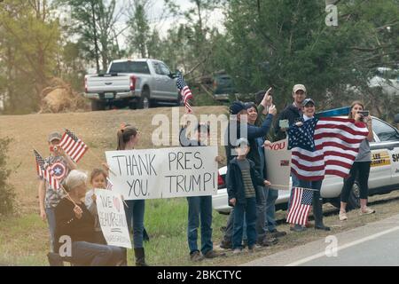 Bewohner werden entlang der Straße in ihrer verwüsteten Nachbarschaft gesehen, als sie Präsident Donald J. Trump und First Lady Melania Trump am Freitag, 8. März 2019, im Lee County, Ala begrüßen. Präsident Trump und First Lady Melania Trump besuchen Alabama Stockfoto