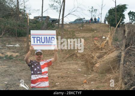 Bewohner werden entlang der Straße in ihrer Tornado verwüsteten Nachbarschaft gesehen, als sie Präsident Donald J. Trump und First Lady Melania Trump Freitag, 8. März 2019, in Lee County, Ala begrüßen. Präsident Trump und First Lady Melania Trump besuchen Alabama Stockfoto