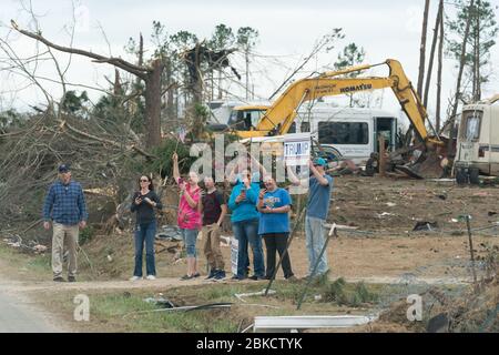 Bewohner werden entlang der Straße in ihrer Tornado verwüsteten Nachbarschaft gesehen, als sie Präsident Donald J. Trump und First Lady Melania Trump Freitag, 8. März 2019, in Lee County, Ala begrüßen. Präsident Trump und First Lady Melania Trump besuchen Alabama Stockfoto