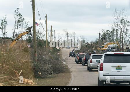 Bewohner werden entlang der Straße in ihrer Tornado verwüsteten Nachbarschaft gesehen, als sie Präsident Donald J. Trump und First Lady Melania Trump Freitag, 8. März 2019, in Lee County, Ala begrüßen. Präsident Trump und First Lady Melania Trump besuchen Alabama Stockfoto