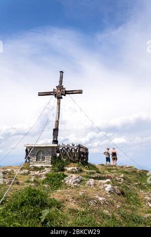 Unbekanntes Paar vor dem Kreuz am Sonntagskogel in den Alpen, Sankt Johann im Pongau, Österreich Stockfoto