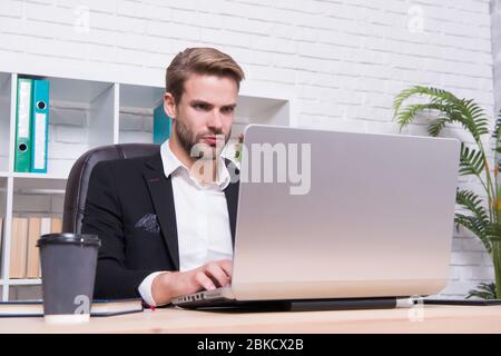 Konzentrierter Broker. Wirtschaft Rezession und Erholung. Finanzexperte Mann arbeiten mit Laptop trinken Kaffee. Börsenkonzept. Finanzielle Investitionen Kryptowährung. Finanzdirektorbüro. Stockfoto