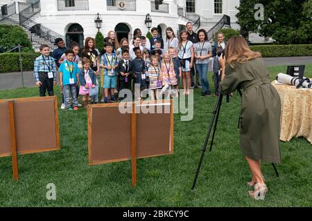 First Lady Melania Trump macht ein Foto von Kindern, die am 25. April 2019 auf dem South Lawn des Weißen Hauses teilnehmen, um unsere Töchter und Söhne zum Work Day zu bringen. Nehmen Sie unsere Töchter und Söhne zum Arbeitstag Stockfoto