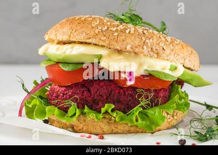 Veggie Burger mit Rote Bete und Avocado auf weißem Marmortisch. Gesunde vegane Lebensmittel. Nahaufnahme Stockfoto