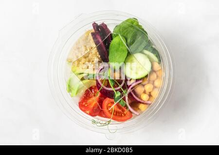 Veganer buddha Schüssel Salat in Kunststoff-Paket zum Mitnehmen oder Lieferung von Lebensmitteln auf weißem Hintergrund. Draufsicht Stockfoto