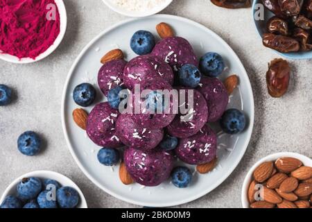 Rohe Energiebälle mit Heidelbeeren, acai-Pulver, Kokosnuss und Mandeln. Gesundes veganes Essen Dessert. Draufsicht. Nahaufnahme Stockfoto