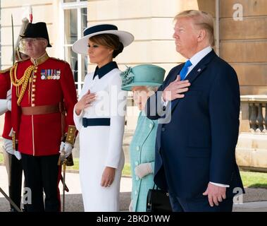Präsident Donald J. Trump und First Lady Melania Trump, zusammen mit der britischen Königin Elizabeth II., legen ihre Hände auf ihr Herz für die Nationalhymne während einer Begrüßungszeremonie am Montag, den 3. Juni 2019 im Buckingham Palace in London. Präsident Trump und First Lady Melania Trumps Reise nach Großbritannien Stockfoto